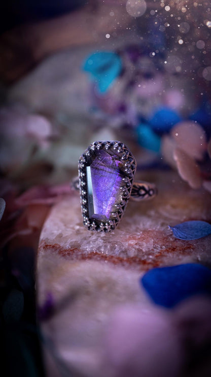 Beautiful and completely handmade, purple labradorite coffin, gothic style, mini statement stacker ring. This ring has been handcrafted using a mix of fine and sterling silver. Featuring a beautiful, purple labradorite gemstone. The crystal is step cut for a sparkle and is full of flash! Around the labradorite is a gothic gallery wire bezel for extra gothic vibes. The ring shank has a one of a kind stamped pattern. Ideal for birthdays and special occasions. Gothic and witchy jewellery.