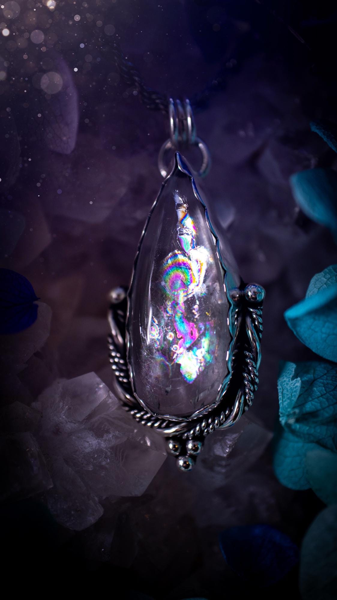 Handmade white topaz pendant necklace crafted from fine silver and sterling silver. The teardrop white topaz gemstone displays stunning natural cluster rainbows and subtle sparkle within the stone. The elegant silver setting highlights the crystal's unique inclusions and clarity. Photographed against a neutral background, this artisan gemstone necklace makes a thoughtful November birthstone gift. A necklace that is the definition of celestial and fairycore!