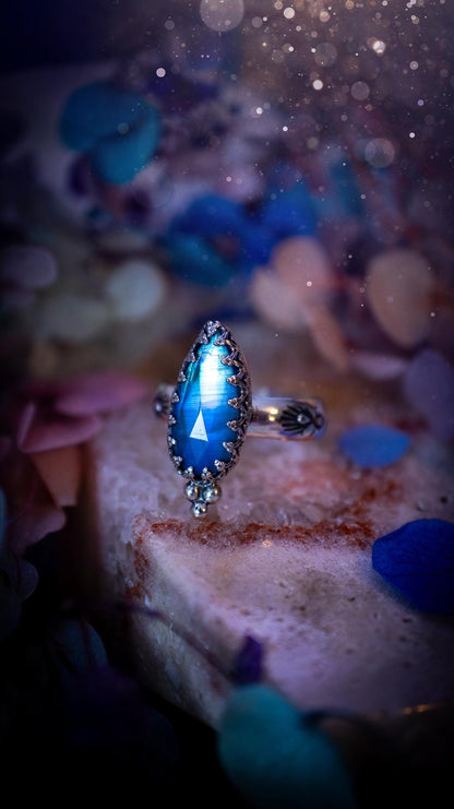 Beautiful and completely handmade, rainbow moonstone, gothic style mini statement stacker ring. This ring has been handcrafted using a mix of fine and sterling silver. Featuring a beautiful, high grade rainbow moonstone. The crystal is rose cut for a sparkle and is full of blue flash! Around the moonstone is a gothic gallery wire bezel, and little silver ball accents. The ring shank has a one of a kind stamped pattern. Ideal for birthdays and special occasions. Gothic and witchy jewellery.