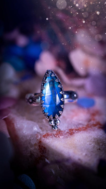 Beautiful and completely handmade, rainbow moonstone, gothic style mini statement stacker ring. This ring has been handcrafted using a mix of fine and sterling silver. Featuring a beautiful, high grade rainbow moonstone. The crystal is rose cut for a sparkle and is full of blue flash! Around the moonstone is a gothic gallery wire bezel, and little silver ball accents. The ring shank has a one of a kind stamped pattern. Ideal for birthdays and special occasions. Gothic and witchy jewellery.