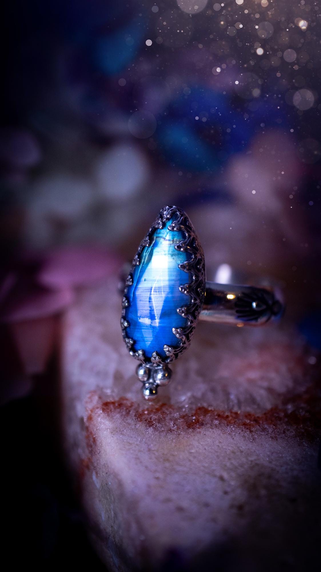 Beautiful and completely handmade, rainbow moonstone, gothic style mini statement stacker ring. This ring has been handcrafted using a mix of fine and sterling silver. Featuring a beautiful, high grade rainbow moonstone. The crystal is rose cut for a sparkle and is full of blue flash! Around the moonstone is a gothic gallery wire bezel, and little silver ball accents. The ring shank has a one of a kind stamped pattern. Ideal for birthdays and special occasions. Gothic and witchy jewellery.