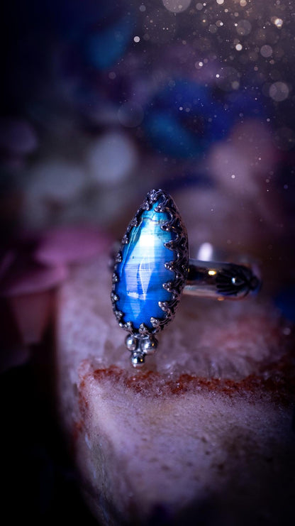 Beautiful and completely handmade, rainbow moonstone, gothic style mini statement stacker ring. This ring has been handcrafted using a mix of fine and sterling silver. Featuring a beautiful, high grade rainbow moonstone. The crystal is rose cut for a sparkle and is full of blue flash! Around the moonstone is a gothic gallery wire bezel, and little silver ball accents. The ring shank has a one of a kind stamped pattern. Ideal for birthdays and special occasions. Gothic and witchy jewellery.