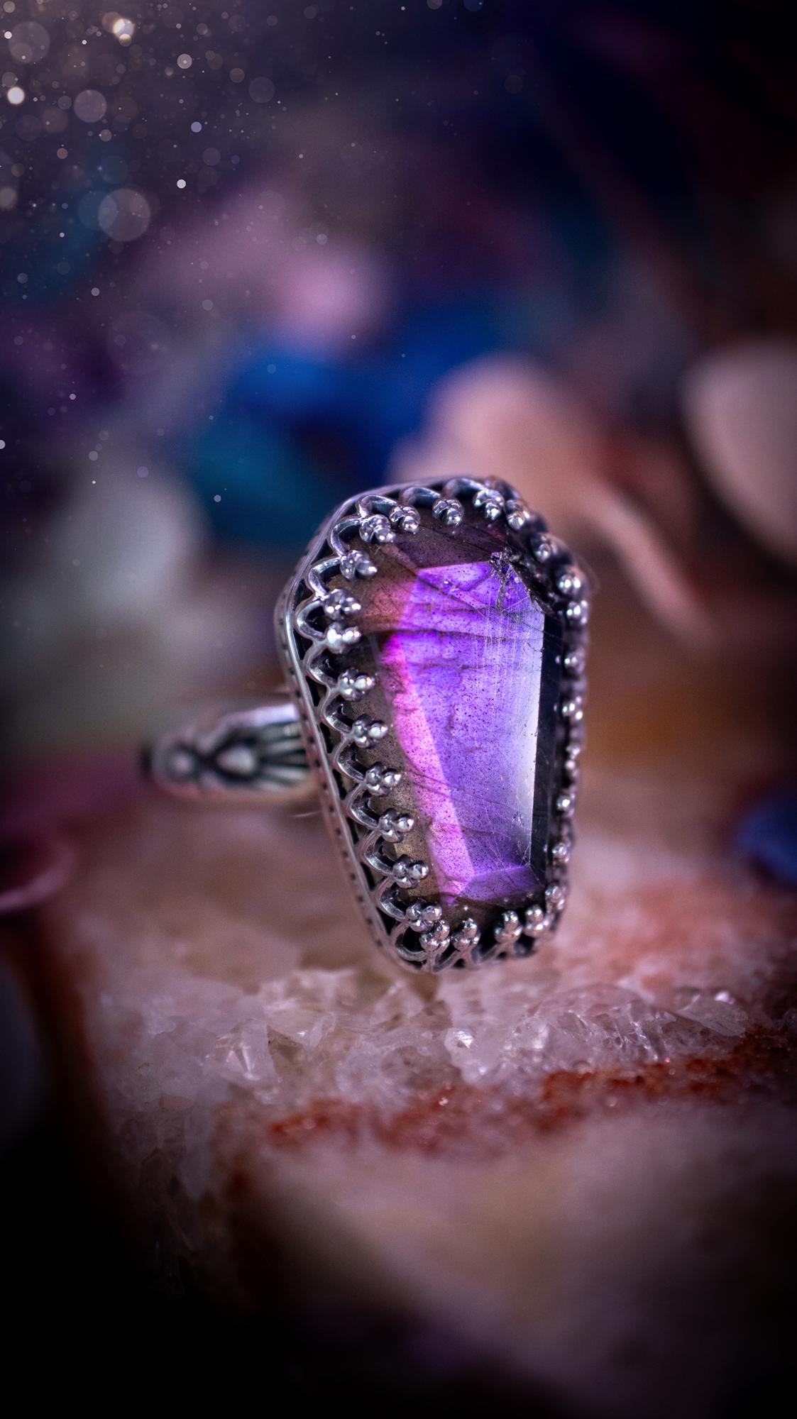 Beautiful and completely handmade, purple labradorite coffin, gothic style, mini statement stacker ring. This ring has been handcrafted using a mix of fine and sterling silver. Featuring a beautiful, purple labradorite gemstone. The crystal is step cut for a sparkle and is full of flash! Around the labradorite is a gothic gallery wire bezel for extra gothic vibes. The ring shank has a one of a kind stamped pattern. Ideal for birthdays and special occasions. Gothic and witchy jewellery.