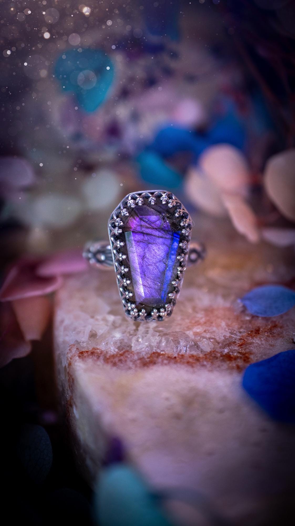 Beautiful and completely handmade, purple labradorite coffin, gothic style, mini statement stacker ring. This ring has been handcrafted using a mix of fine and sterling silver. Featuring a beautiful, purple labradorite gemstone. The crystal is step cut for a sparkle and is full of flash! Around the labradorite is a gothic gallery wire bezel for extra gothic vibes. The ring shank has a one of a kind stamped pattern. Ideal for birthdays and special occasions. Gothic and witchy jewellery.