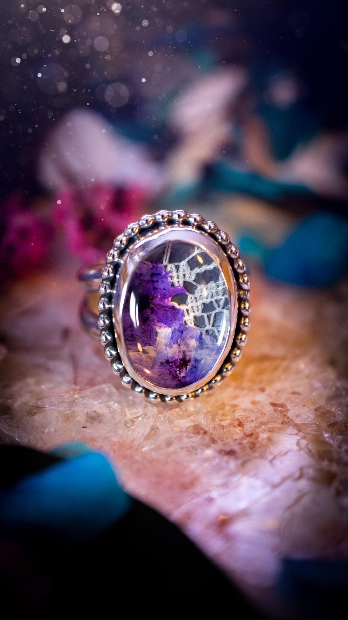 Beautiful and one of a kind, quartz crystal, botanical mini statement ring. This ring has been made by placing lace and real dried flowers under a smooth, quartz crystal. Handmade from fine and sterling silver, featuring a smooth bezel, beaded wire around the bezel and a smooth double ring band. A very unique piece to gift to a loved one who may love crystals and flowers. Ideal for birthdays, anniversaries, and any special occasion. A unique take to sterling silver jewellery.