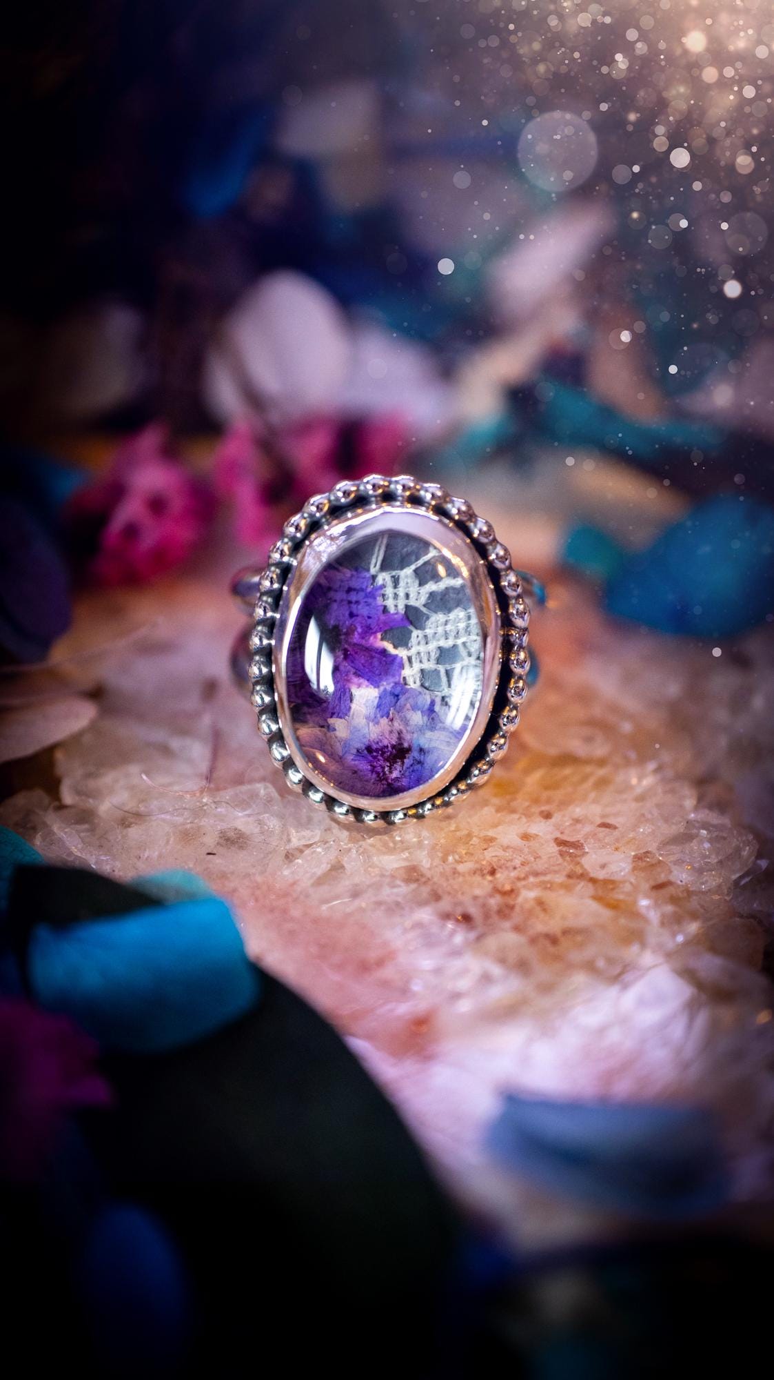 Beautiful and one of a kind, quartz crystal, botanical mini statement ring. This ring has been made by placing lace and real dried flowers under a smooth, quartz crystal. Handmade from fine and sterling silver, featuring a smooth bezel, beaded wire around the bezel and a smooth double ring band. A very unique piece to gift to a loved one who may love crystals and flowers. Ideal for birthdays, anniversaries, and any special occasion. A unique take to sterling silver jewellery.