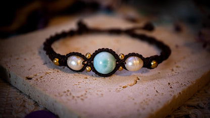 Beautiful and handmade, larimar with fresh water pearls macrame bracelet. This bracelet has been handmade using high quality Linhasita wax cord which is a dark brown colour. Featuring stunning, high quality Larimar crystal beads that are full of natural pattern. There are brass beads within the macrame pattern and fresh water pearls. A lovely little gift for a close one, or a little treat for yourself! Ideal for birthdays, anniversaries, and special occasions. Hippy jewellery for the soul.