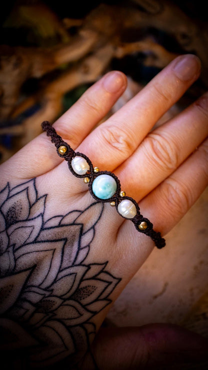 Beautiful and handmade, larimar with fresh water pearls macrame bracelet. This bracelet has been handmade using high quality Linhasita wax cord which is a dark brown colour. Featuring stunning, high quality Larimar crystal beads that are full of natural pattern. There are brass beads within the macrame pattern and fresh water pearls. A lovely little gift for a close one, or a little treat for yourself! Ideal for birthdays, anniversaries, and special occasions. Hippy jewellery for the soul.