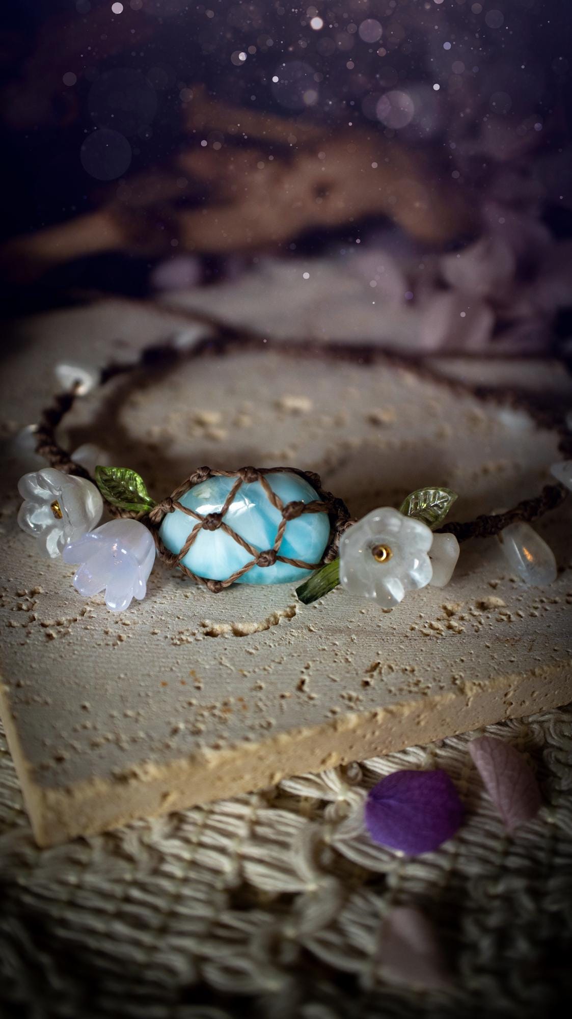 Beautifully handmade, authentic and natural crystal larimar, macrame fairy bracelet. This bracelet has been made using high quality Linhasita waxed cord in cedar brown colour. Featuring a beautiful larimar crystal as the focal point that is surrounded by glass flowers that have 24k plated gold beads, moonstone chip crystals and little cute leaves. The bracelet also has a slider knot for size adjustments. Ideal for anyone who loves a whimsical aesthetic, crystals, florals and hippy jewellery.