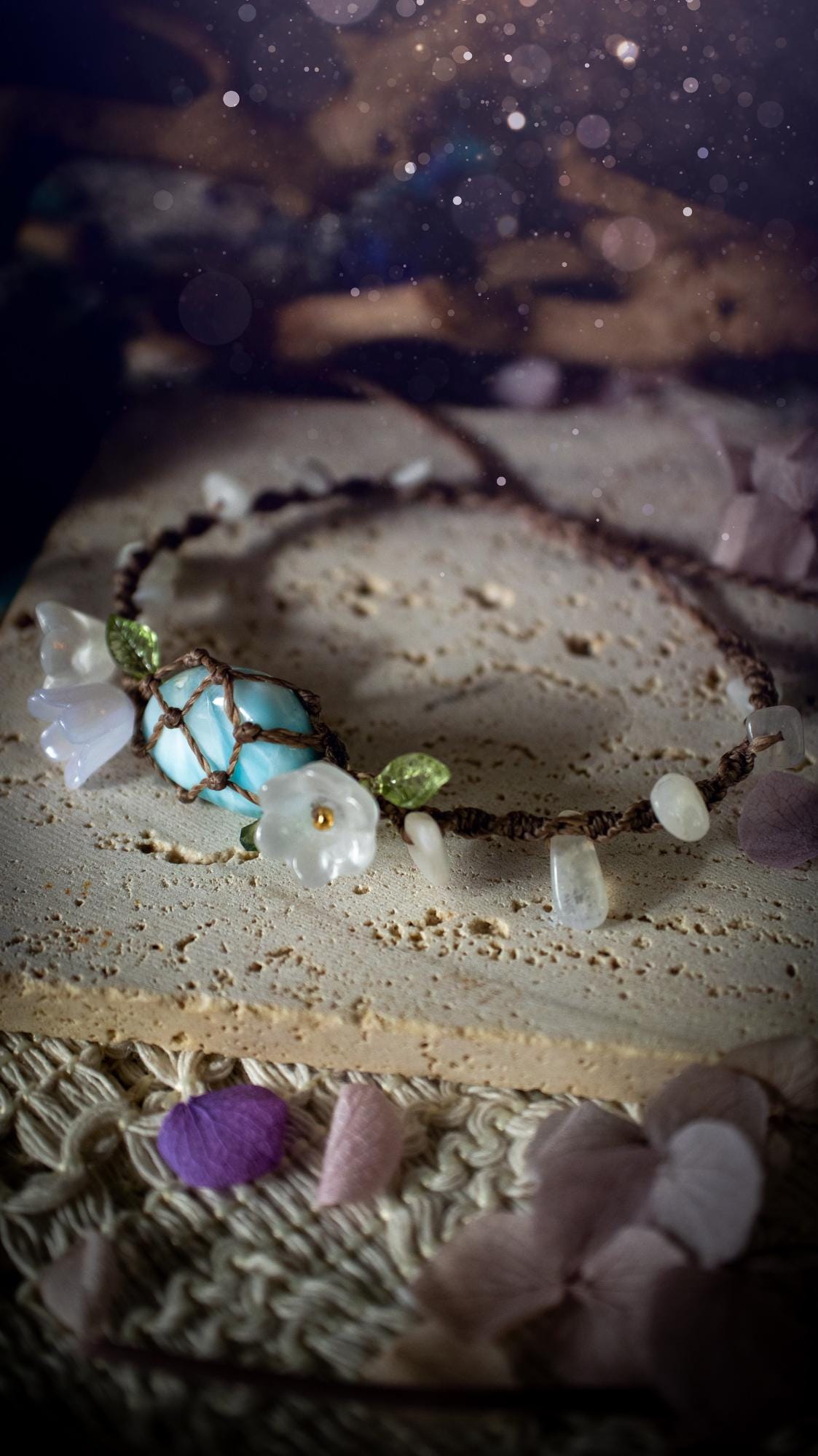 Beautifully handmade, authentic and natural crystal larimar, macrame fairy bracelet. This bracelet has been made using high quality Linhasita waxed cord in cedar brown colour. Featuring a beautiful larimar crystal as the focal point that is surrounded by glass flowers that have 24k plated gold beads, moonstone chip crystals and little cute leaves. The bracelet also has a slider knot for size adjustments. Ideal for anyone who loves a whimsical aesthetic, crystals, florals and hippy jewellery.