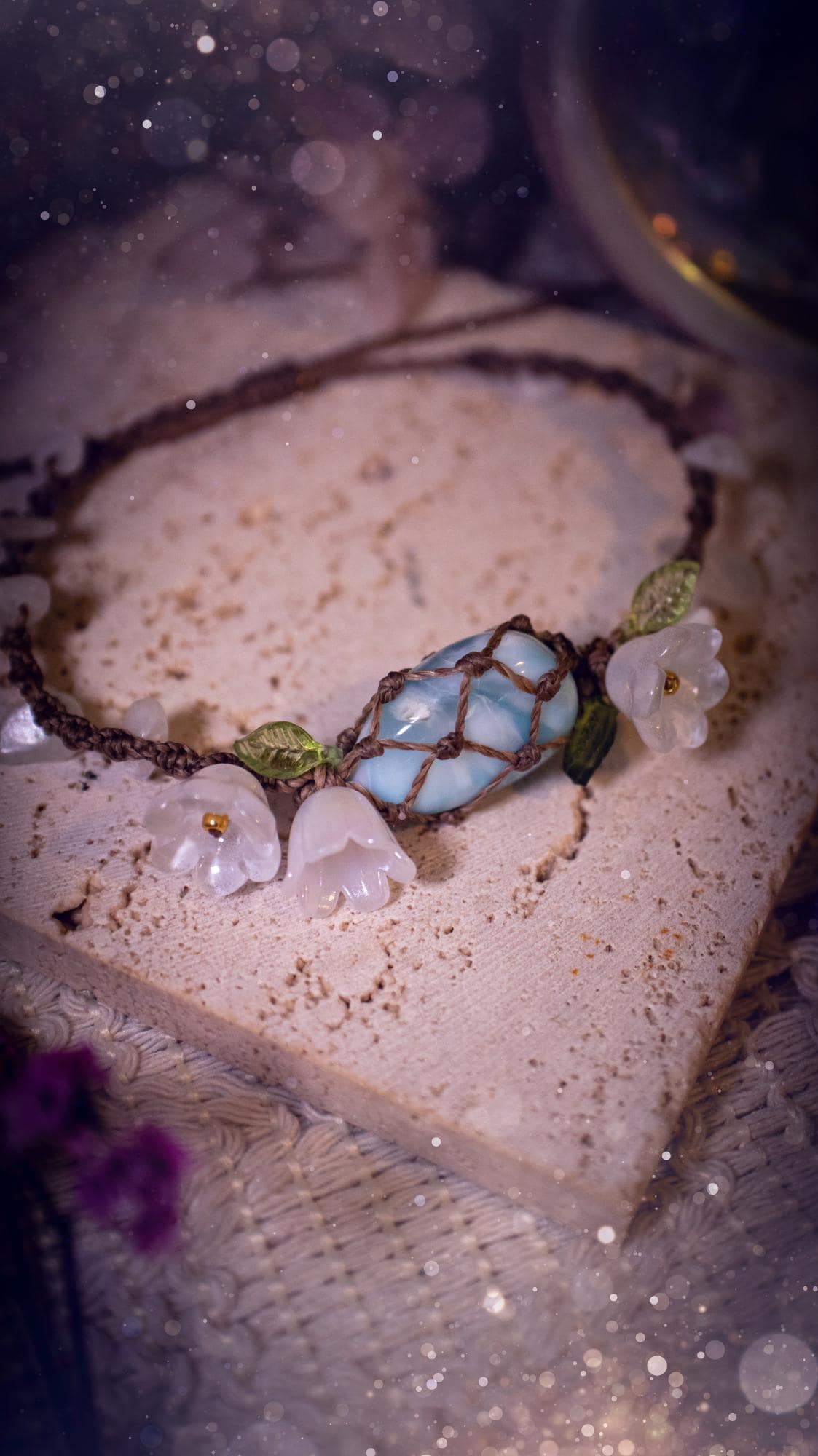 Beautifully handmade, authentic and natural crystal larimar, macrame fairy bracelet. This bracelet has been made using high quality Linhasita waxed cord in cedar brown colour. Featuring a beautiful larimar crystal as the focal point that is surrounded by glass flowers that have 24k plated gold beads, moonstone chip crystals and little cute leaves. The bracelet also has a slider knot for size adjustments. Ideal for anyone who loves a whimsical aesthetic, crystals, florals and hippy jewellery.