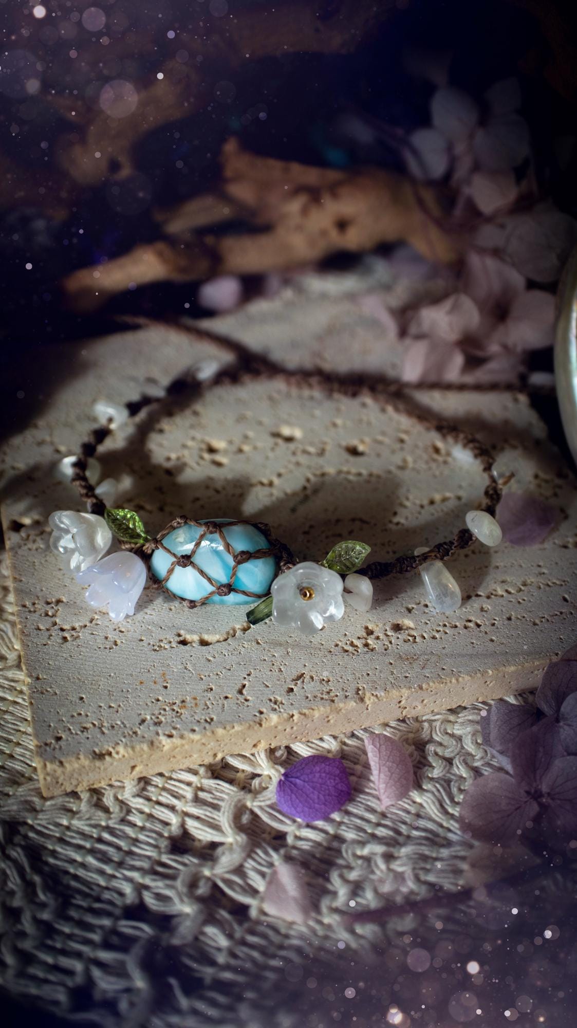 Beautifully handmade, authentic and natural crystal larimar, macrame fairy bracelet. This bracelet has been made using high quality Linhasita waxed cord in cedar brown colour. Featuring a beautiful larimar crystal as the focal point that is surrounded by glass flowers that have 24k plated gold beads, moonstone chip crystals and little cute leaves. The bracelet also has a slider knot for size adjustments. Ideal for anyone who loves a whimsical aesthetic, crystals, florals and hippy jewellery.