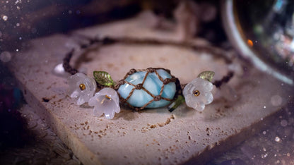 Beautifully handmade, authentic and natural crystal larimar, macrame fairy bracelet. This bracelet has been made using high quality Linhasita waxed cord in cedar brown colour. Featuring a beautiful larimar crystal as the focal point that is surrounded by glass flowers that have 24k plated gold beads, moonstone chip crystals and little cute leaves. The bracelet also has a slider knot for size adjustments. Ideal for anyone who loves a whimsical aesthetic, crystals, florals and hippy jewellery.