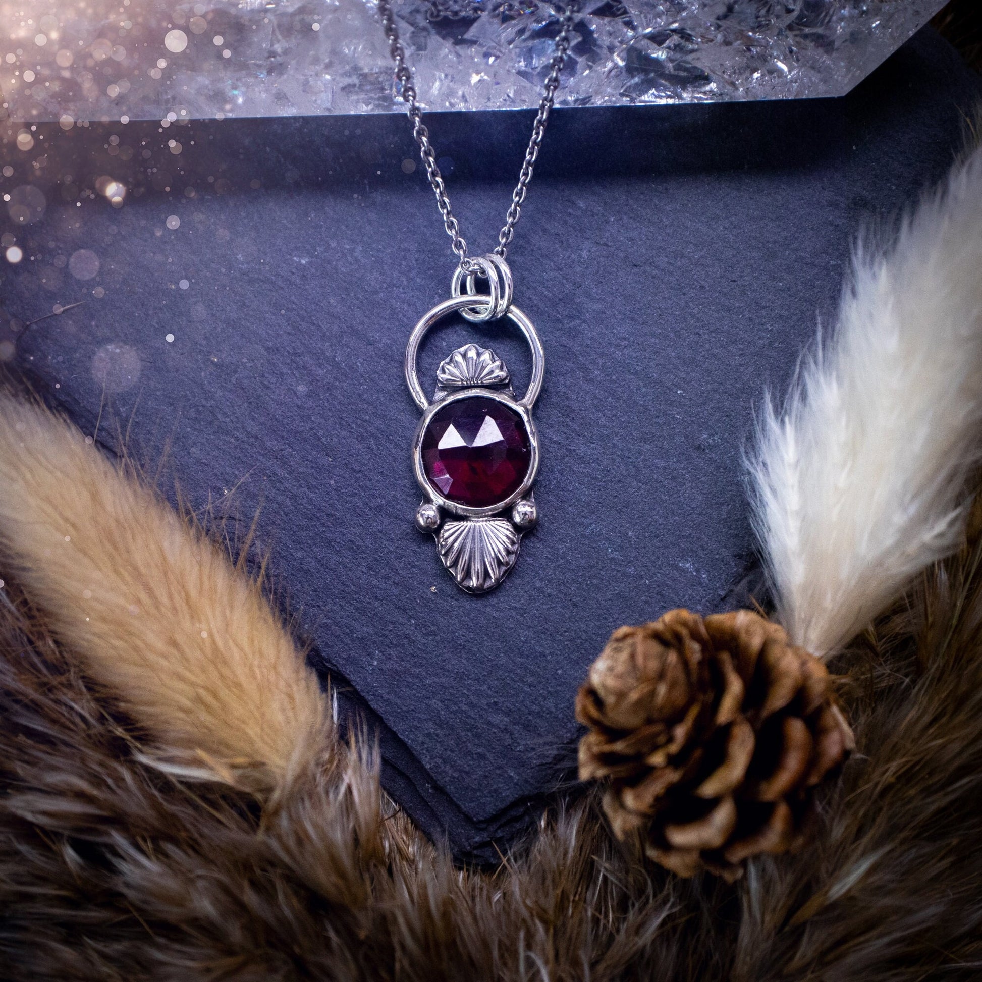 Beautiful, rose cut garnet sterling silver pendant. This little pendant has been handmade with love and care and has the most stunning pinks and reds within the gemstone. Accompanied by silver components including a free chain. Ideal crystal gift.