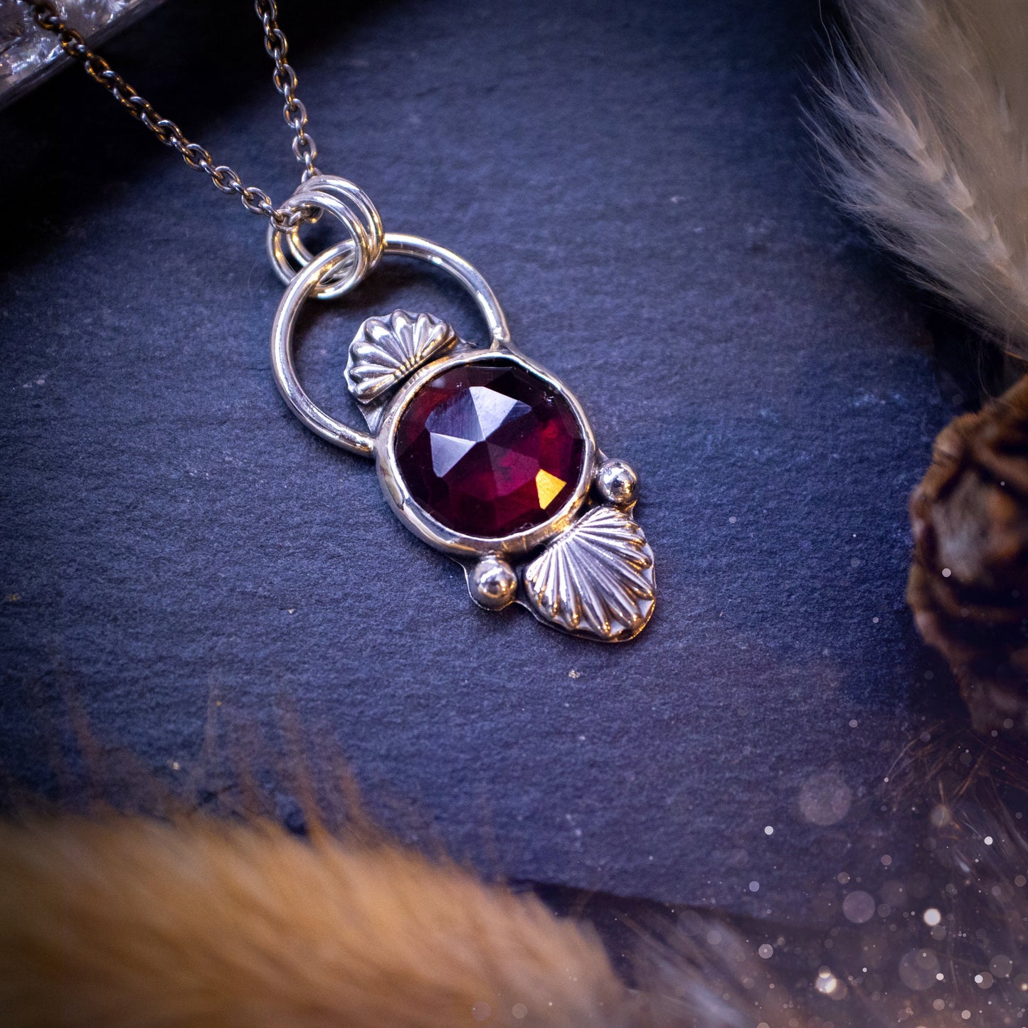 Beautiful, rose cut garnet sterling silver pendant. This little pendant has been handmade with love and care and has the most stunning pinks and reds within the gemstone. Accompanied by silver components including a free chain. Ideal crystal gift.