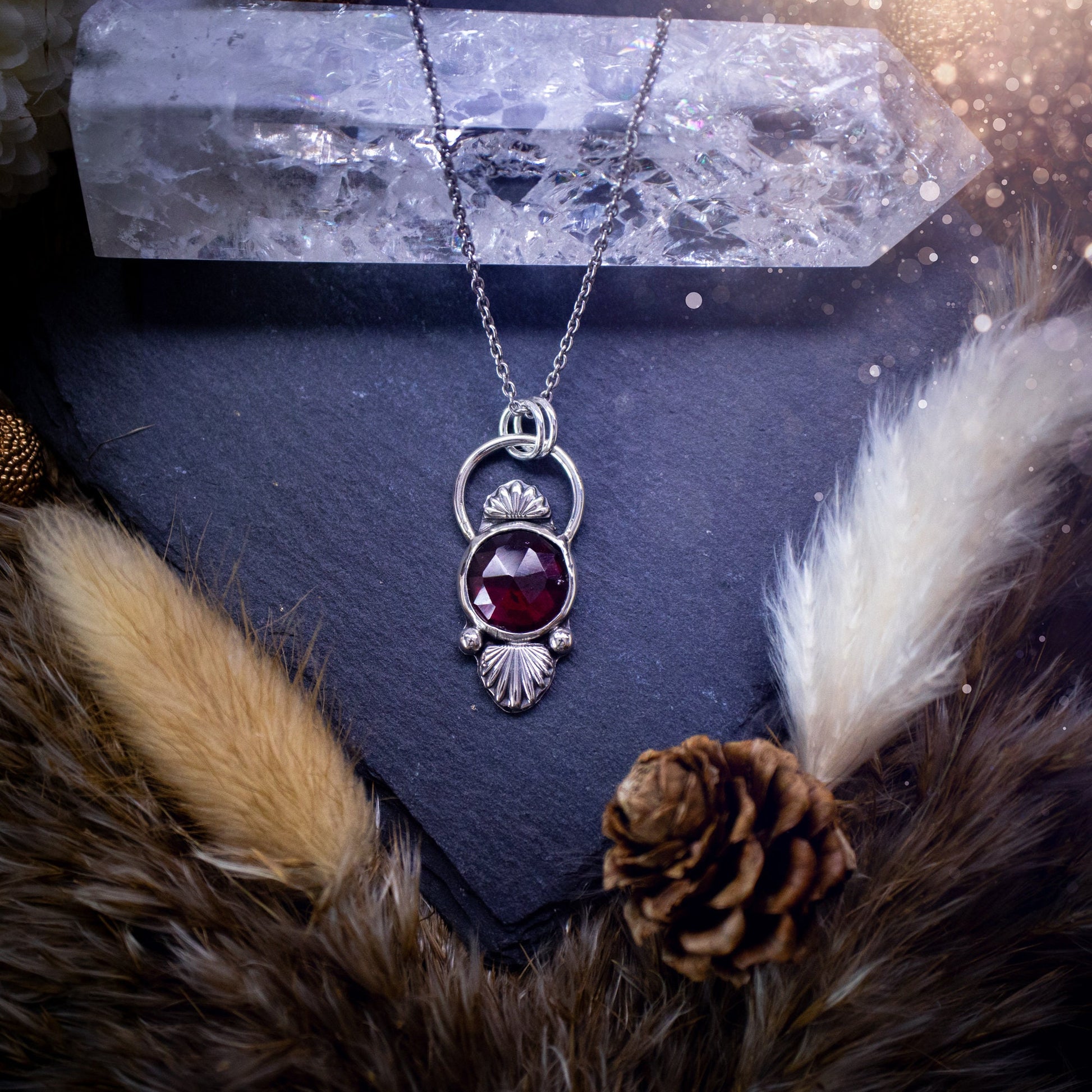 Beautiful, rose cut garnet sterling silver pendant. This little pendant has been handmade with love and care and has the most stunning pinks and reds within the gemstone. Accompanied by silver components including a free chain. Ideal crystal gift.